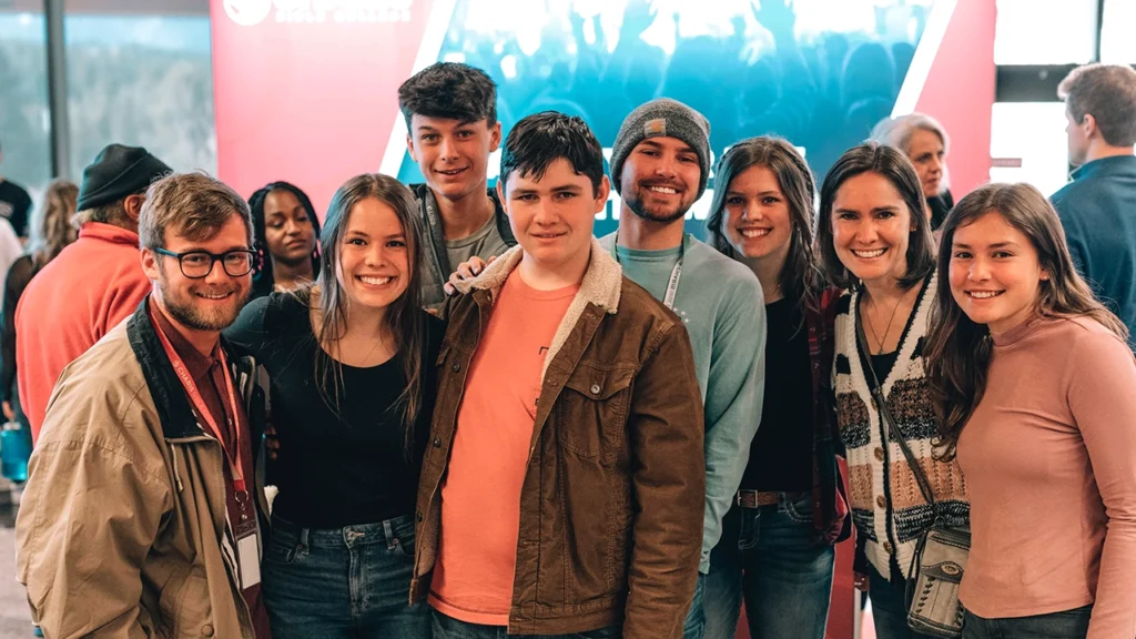 A group of students smiling and enjoying their time at Charis Bible College, gathered in a lively and welcoming environment.