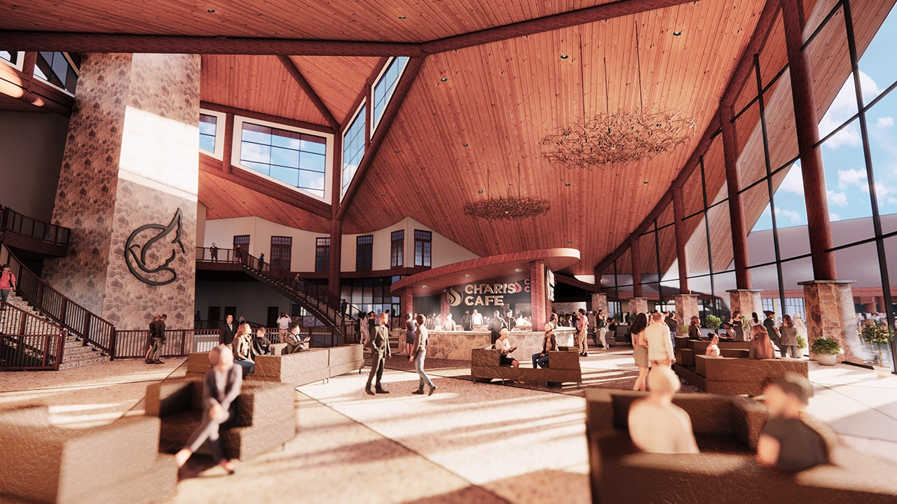 A grand, open-concept lobby with high wooden ceilings, large windows, and a spacious seating area filled with people. The "Charis Café" serves as a focal point, with guests socializing and ordering refreshments. A stone pillar with a distinctive emblem adds to the rustic, modern aesthetic, while chandeliers and natural lighting create a warm, inviting atmosphere.