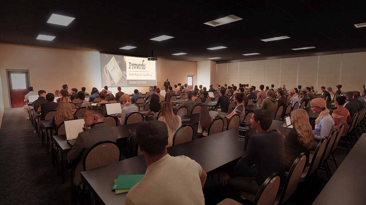 A classroom-style lecture hall filled with students attentively listening to a speaker at the front. The presentation screen displays a slide titled "Proverbs: Timeless Wisdom for a Life of Blessing" by Andrew Wommack. Attendees are seated at long tables, some taking notes on laptops or notebooks, in a well-lit, professional learning environment.