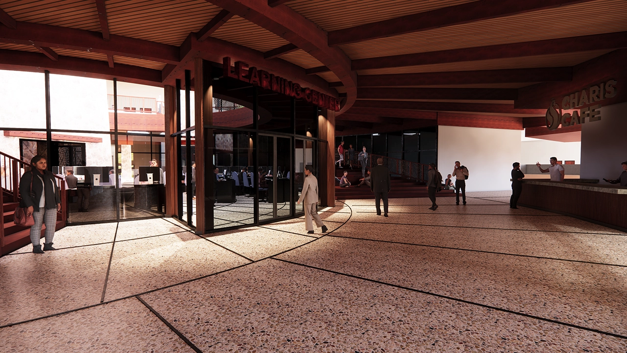 A spacious lobby area featuring the "Learning Center" enclosed in glass, with people walking and engaging in conversation. To the right, the "Charis Café" counter serves visitors, while others sit on nearby steps. The warm wood tones, high ceilings, and natural lighting create a welcoming and modern atmosphere.